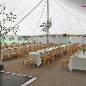 Natural wood banquet chairs in traditional marquee